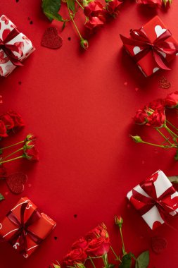 Kırmızı güllerin, paketlenmiş hediyelerin ve cesur kırmızı arka planda kalp aksanlarının olduğu romantik dikey sevgililer günü sahnesi. Tebrik kartları, aşk mesajları ve kutlama temaları için mükemmel.