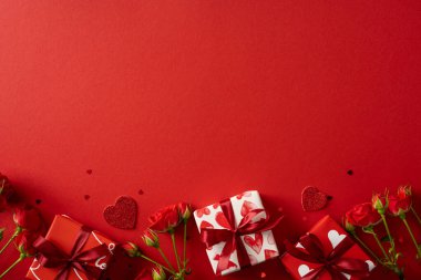 Güller, hediyeler ve parıltılı kalplerle dolu kırmızı temalı romantik bir sergi sevgi, şefkat, kutlama, hediye verme ve neşeli sevgililer günü havasını taşır.