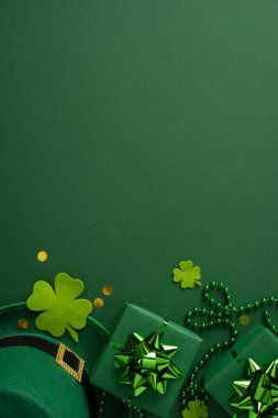 Yonca aksanları, paketlenmiş hediyeler ve şenlikli boncuklar içeren hareketli dikey yeşil kurgu Aziz Patrick Günü atmosferi ve tatil için sıcak bir karşılama ortamı yaratıyor.