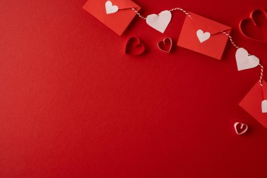 Festivalin kırmızı arka planında kalp kartları ve ip çelenkleri asılarak Sevgililer Günü kutlamaları ve romantik kutlamalar için sıcak ve samimi bir ortam yaratılıyor.