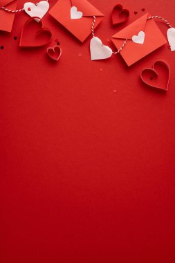 Kırmızı zarflar, beyaz ve kırmızı kalpler ve dekoratif teller içeren hareketli dikey sevgililer günü havası. Tebrik kartları, terfiler ve Valentine temalı projeler için ideal