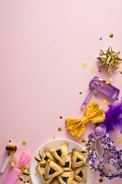 Pembe arka planda maskeli şapkalar, konfeti ve hamantaschen kurabiyelerinin yer aldığı dikey bir Purim sahnesi. Parlak renkler ve dekorasyonlar şenlik havasını ve kutlama havasını parti havalarıyla iletir.