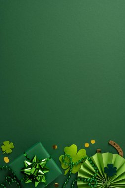 Yeşil bir zemin, yoncalar, boncuklar, paketlenmiş bir hediye ve dekoratif aksanlı şans, İrlanda mirası ve canlı renklerde sezonluk cazibenin yer aldığı şenlikli Aziz Patrick Günü sahnesi.