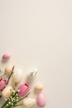 Pastel yumurtalar, beyaz ve pembe laleler ve yumuşak bej bir zemin üzerinde bebek nefesi barındıran dikey, narin, durgun bir hayat. Paskalya dekoru, bahar kutlamaları ve mevsimlik kutlamalar için ideal.