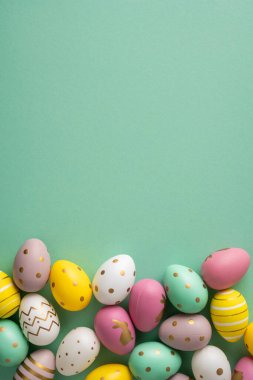 Renkli dikey pastel yumurtalar en alt sınırda. Baharı, yenilenmeyi ve mutlu bir tatil için sıcak selamları kutlayan parlak bir Paskalya sahnesi yaratıyorlar.
