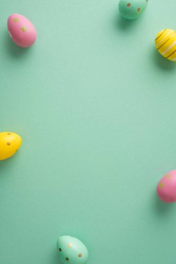 Pastel dikey dekore edilmiş Paskalya yumurtaları nane yeşili arka planda mutlu bir bahar selamı ve mevsimsel kutlama için düzenlenmiştir.