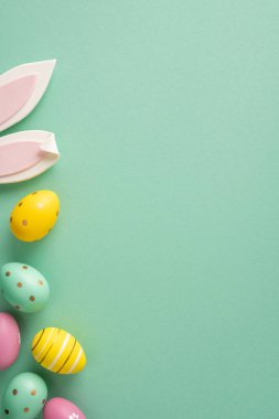 Pastel boyanmış yumurtalar, dekoratif tavşan kulakları ve darphane arkaplanındaki bir mesaj için boşluk içeren Paskalya bayramın kutlu olsun.