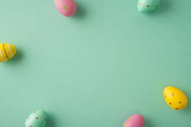 Mutlu Paskalya kutlamaları ve nane yeşili arkaplan etrafında düzenlenmiş pastel süslemeli yumurtalar ile tebrik kartları posterleri veya sosyal medya promosyonları için telif alanı ile