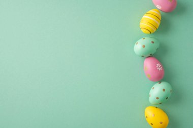 Nane yeşili bir zemin üzerine dizilmiş pastel yumurtaların yer aldığı Paskalya bayramın kutlu olsun. Bahar kutlaması, kartlar, afişler ve tatil promosyonları için neşeli mevsimsel dekorasyon.