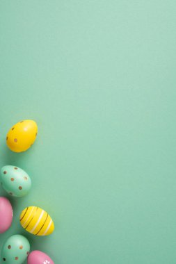 Bahar kutlaması ve mevsimlik dekorasyon için nane yeşili arka planda boyanmış pastel yumurtaların yer aldığı Paskalya bayramınız kutlu olsun.