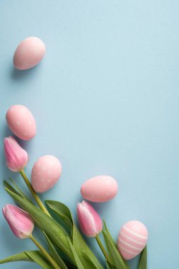 Mutlu Paskalya dikey kutlamaları. Pastel pembe süslemeli yumurtalar ve bahar tatili kartları ve davetiyeleri için mavi bir arka planda düzenlenmiş lale ile.