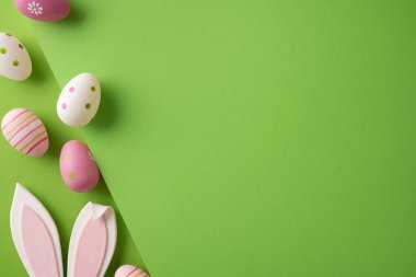 Mutlu Paskalya pastel dekore edilmiş yumurta ve tavşan kulakları parlak yeşil bir arkaplanda mevsimsel selamlaşma ya da terfi için temiz fotokopi alanı sunuyor.