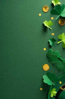 Kutlama için koyu yeşil bir zemin üzerinde kağıt yoncalar, altın paralar, konfeti ve bir leprikon şapkayla Aziz Patrick Günü kompozisyonu.