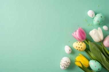Mutlu Paskalya kompozisyonu: Pastel lale ve el boyası yumurta arkaplanda bahar şenlik havasını taşıyor.