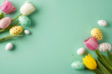 Happy Easter concept with decorated eggs and colorful tulip flowers arranged on a mint pastel background evoking spring celebration and festive mood