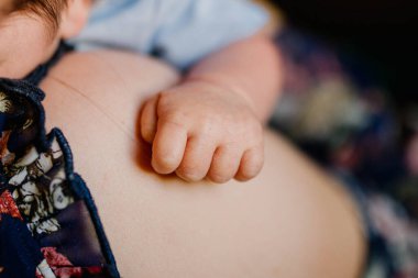 Küçük bir çocuğun eli annesini sıkıca tutuyor.