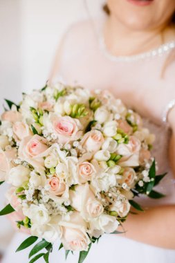 Gelinin ellerinde bir buket beyaz ve pembe küçük güller