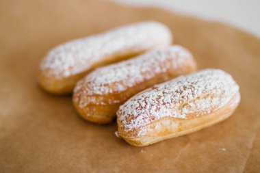 Kahverengi bir masada şeker tozuyla ev yapımı kek ekleri. Doldurulmuş eklem. Geleneksel ekinler, kârlar klasik, eklem fransızı..