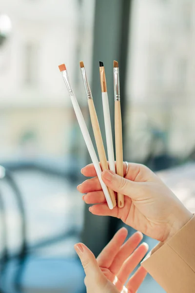 Closeup of a eyebrow brushes in the hands of a master