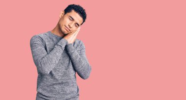 İspanyol yakışıklı genç adam rahat bir süveter giyer uyur. Yorgun düşler kurar, elleriyle poz verir ve gözleri kapalı gülümserdi.. 