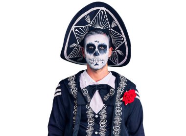 Arka planda ölü kostümü giyen genç adam yüzünde ciddi bir ifadeyle rahatlamış. Basit ve doğal bir şekilde kameraya bakıyorsun.. 