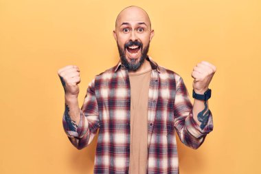 Gündelik kıyafetler giyen genç yakışıklı adam gururla bağırıyor zaferi ve başarıyı kutluyor. Kollarını kaldırarak heyecanla bekliyor. 