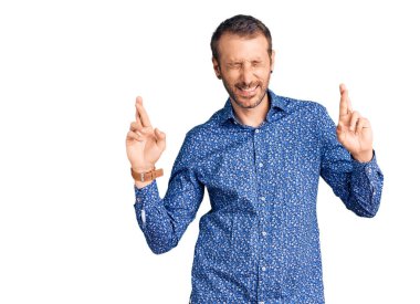 Sıradan kıyafetler giyen genç yakışıklı adam umut ve gözlerin kapalı gülümseyerek el sallıyor. Şans ve batıl inançlar. 