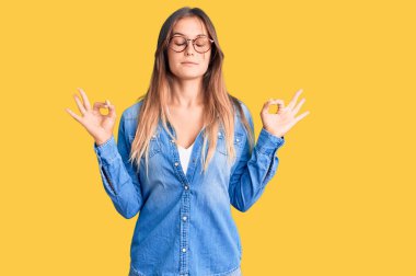 Güzel beyaz kadın, günlük kıyafetler ve gözlük takmış kameraya bakıyor sarılmak için kollarını açmış gülümsüyor. Mutluluğu kucaklayan neşeli bir ifade.. 