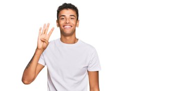 Genç, yakışıklı, Afro-Amerikalı, günlük beyaz tişörtler giyen, dört numarayı gösteren ve gülümseyen, kendinden emin ve mutlu bir adam.. 