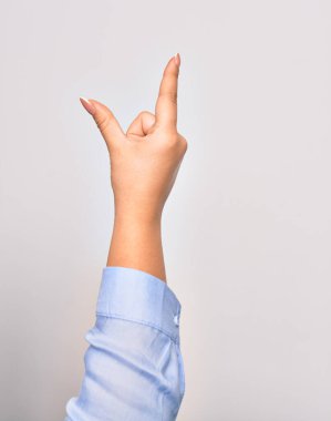 Beyaz arka planda yakalama işareti yapan beyaz bir kadın.