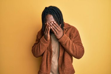 Kahverengi retro ceket giyen Afrika kökenli Amerikalı bir adam yorgunluk ve baş ağrısı için gözlerini ovuşturuyor, uykulu ve yorgun bir ifade takınıyor. görme sorunu 