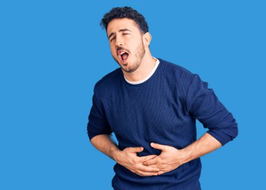 Mide bulantısı, acı verici bir hastalık yüzünden günlük giysiler giyen genç İspanyol bir adam. Ağrı kavramı. 