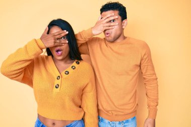 Güzel Latin genç çift, günlük kıyafetlerini giyip şok içinde yüzlerini ve gözlerini kapayarak utangaç bir ifadeyle parmaklarından bakıyorlar.. 