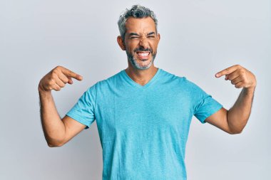 Orta yaşlı, gri saçlı, günlük kıyafetler giyen, kendine güvenen, gülümseyen, kendini gururlu ve mutlu gösteren bir adam.. 