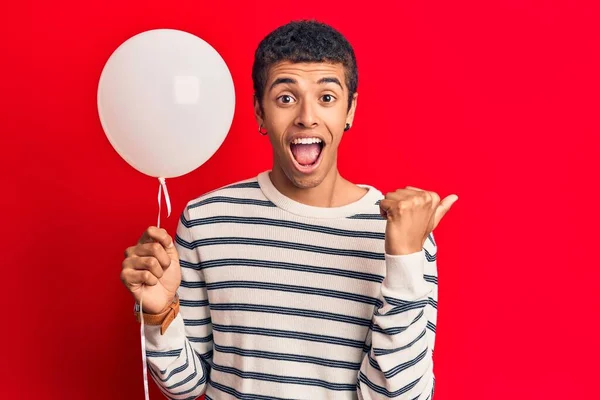 Jovem Afro Americano Segurando Balão Apontando Polegar Para Lado Sorrindo — Fotografia de Stock