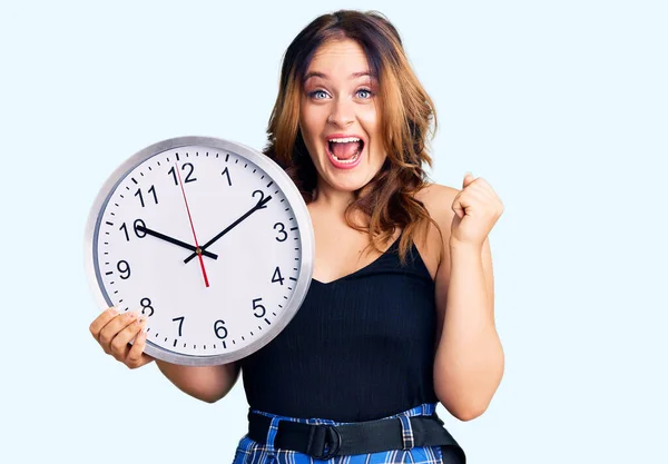 Young Beautiful Caucasian Woman Holding Big Clock Screaming Proud Celebrating — Stock Photo, Image