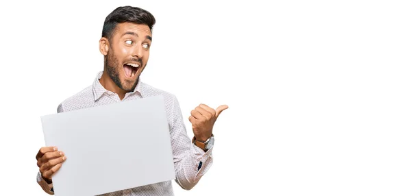 Handsome Hispanic Man Holding Blank Empty Banner Pointing Thumb Side — Stock Photo, Image