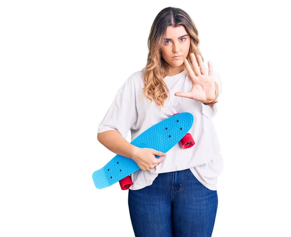 Jovem Mulher Caucasiana Segurando Skate Com Mão Aberta Fazendo Sinal — Fotografia de Stock