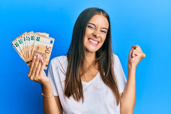 Young Hispanic Woman Holding Euro Banknotes Screaming Proud Celebrating Victory — Stock Photo, Image