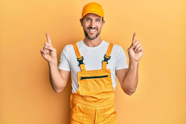 Ung Stilig Man Bär Handyman Uniform Över Gul Bakgrund Ler — Stockfoto