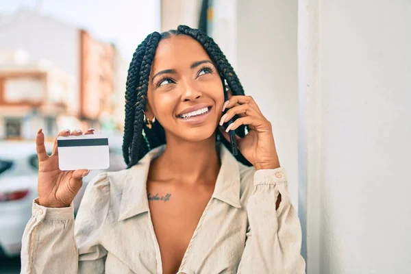 Νεαρή Αφροαμερικανή Γυναίκα Χαμογελά Ευτυχισμένη Μιλώντας Στο Smartphone Και Κρατώντας — Φωτογραφία Αρχείου
