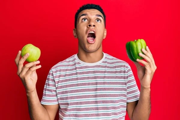 Hombre Árabe Joven Sosteniendo Manzana Verde Pimienta Enojado Loco Gritando —  Fotos de Stock