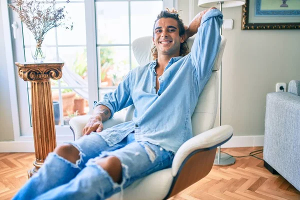 Joven Hombre Hispano Sonriendo Feliz Sentado Sofá Casa —  Fotos de Stock