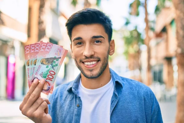 若いラテン人の笑顔幸せな保持新しい熱意100ドル紙幣で街を歩く — ストック写真