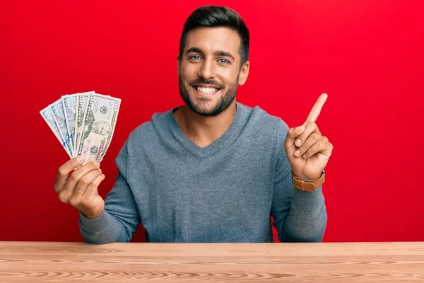 Hombre Hispano Guapo Sosteniendo Dólares Sonriendo Feliz Señalando Con Mano — Foto de Stock