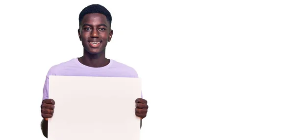 Jovem Afro Americano Segurando Banner Vazio Branco Olhando Positivo Feliz — Fotografia de Stock