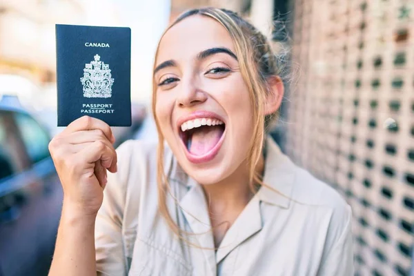 在一个阳光灿烂的日子里 年轻美丽的金发美女带着加拿大护照 在户外快乐地笑着 — 图库照片