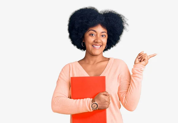 Jovem Afro Americana Segurando Livro Sorrindo Feliz Apontando Com Mão — Fotografia de Stock