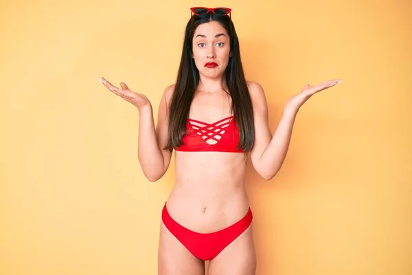 Junge Schöne Kaukasische Frau Bikini Ahnungslos Und Verwirrt Mit Erhobenen — Stockfoto