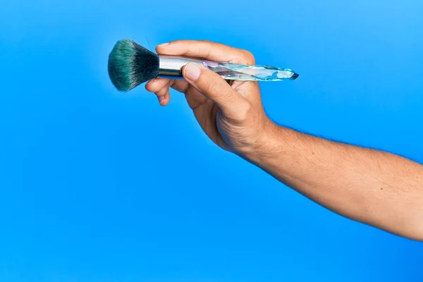 Main Homme Hispanique Tenant Une Brosse Maquillage Sur Fond Bleu — Photo